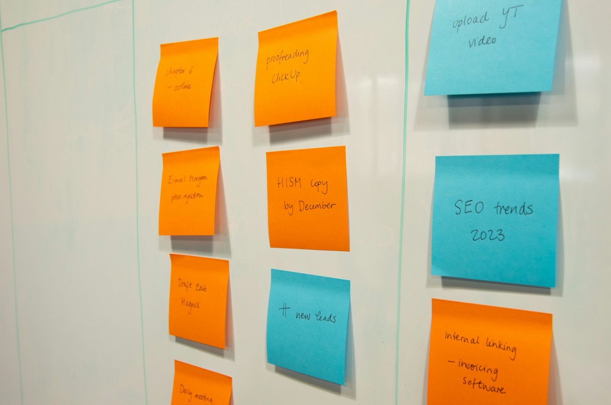 A whiteboard of handwritten sticky notes arranged in columns.
