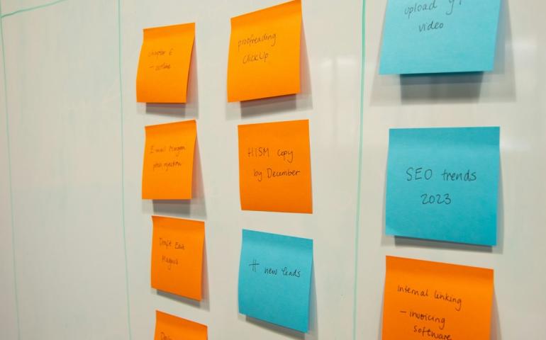 Kanban board with sticky notes moving through columns