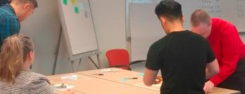 Workshop participants working through a decision-making exercise with sticky notes at a shared table